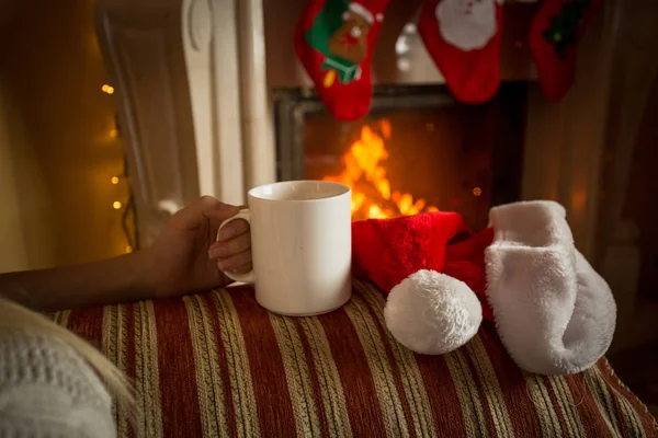 Closeup image of cup of tea on sofa at fireplace — Stock Photo, Image