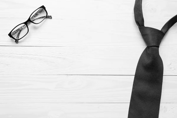 Black adn white image of male necktie and eyeglasses lying on wh — Stock Photo, Image