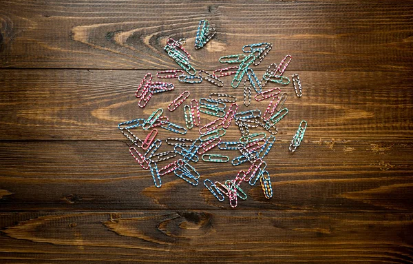 Colorful paperclips and vintage notebook on wooden desk. Backgro — Stock Photo, Image