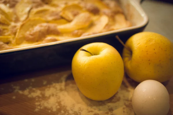 Närbild av nybakade äpple och gyllene äpplen på köksbord — Stockfoto