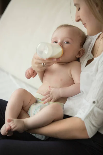 美丽的年轻母亲，用牛奶喂她可爱的小宝贝男孩 — 图库照片