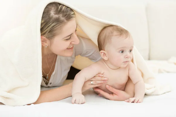 Retrato de madre joven feliz acostada con su hijo de 6 meses en la cama — Foto de Stock