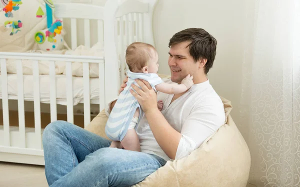 Szczęśliwy młody człowiek, grając z jego dziecko w sypialni — Zdjęcie stockowe