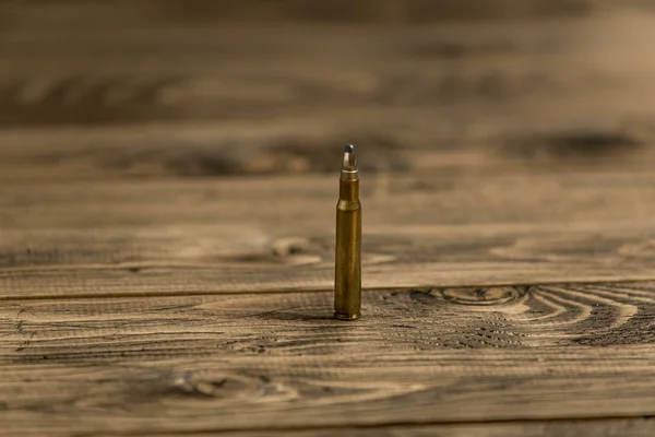Imagem de close-up da bala riffle Kalashikov na velha mesa de madeira — Fotografia de Stock