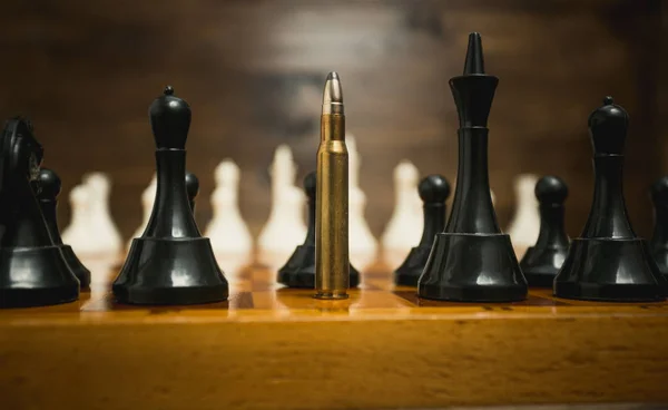 Stora räfflad kula bland schackpjäser. Begreppet vapen makt — Stockfoto