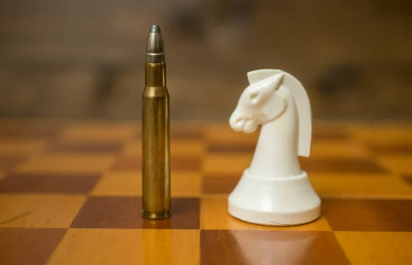 Closeup photo of bullet standing on chessboard with another ches — Stock Photo, Image