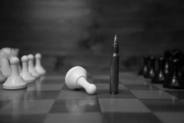 Black and white photo of riffle bullet on chessboard. Concept of — Stock Photo, Image