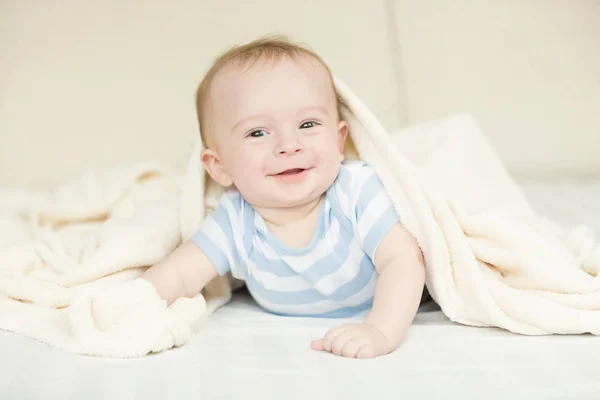 Retrato de lindo bebé niño acostado debajo de la manta — Foto de Stock