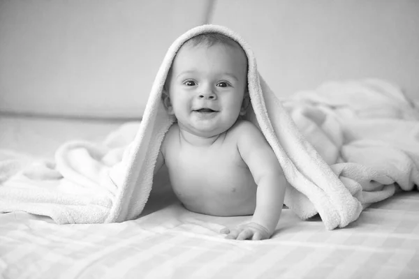 黑色和白色的可爱笑的婴儿躺在空白下的肖像 — 图库照片