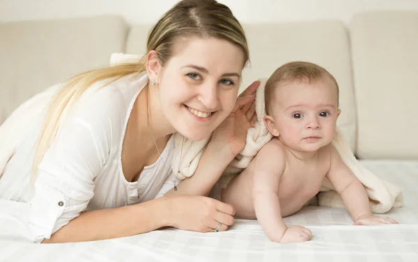 Happy lacht moeder en baby omvatten met deken op bed — Stockfoto