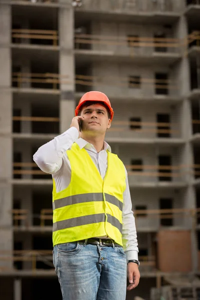 Mladá stavební inženýr mluvil telefonicky na staveništi — Stock fotografie