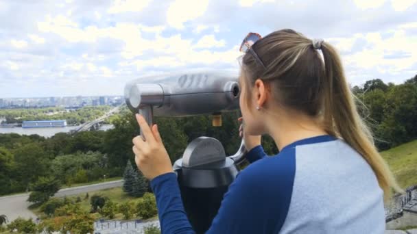 Mulher bonita usando moeda binocular pago e olhando para a cidade — Vídeo de Stock