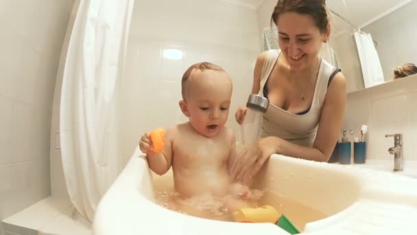 Slow motion beelden van schattige babyjongen Baden en spatten — Stockvideo