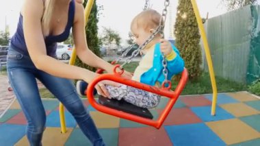 Mutlu gülen bebek annesiyle salıncakta sallanan Slow motion video