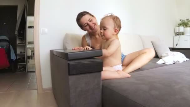 Nuttet baby dreng åbner skuffe med tøj og ser inde – Stock-video