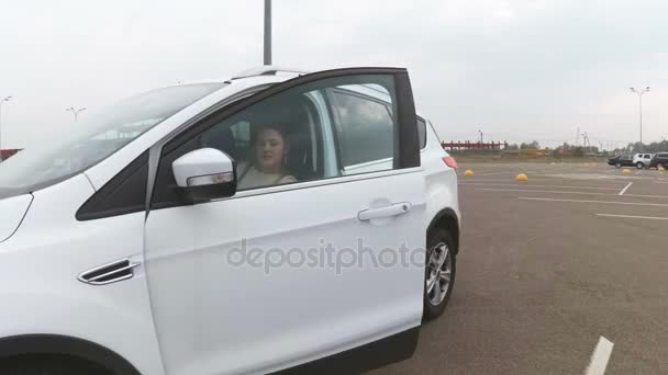 Hermosa joven saliendo del coche y caminando hacia el supermercado — Vídeo de stock