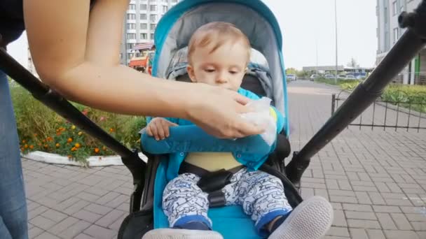 Jonge moeder haar baby jongen handen met natte zakdoek schoonmaken — Stockvideo