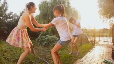 Bahçe Hortum boru su sıçramasına mutlu neşeli Aile ağır çekim görüntüleri