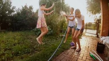 Mutlu çocuk bahçe hortumu su sıçramasına Slow motion video