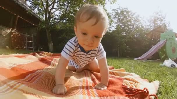 4K video de adorable bebé niño arrastrándose en la hierba en el patio trasero — Vídeo de stock