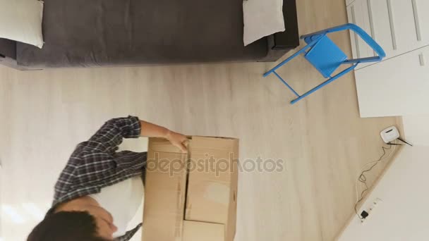 Vista desde arriba en pareja joven llevando cajas en apartamento nuevo — Vídeo de stock