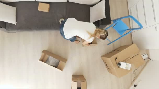 View from the ceiling on young family moving to a new house and carrying boxes — Stock Video