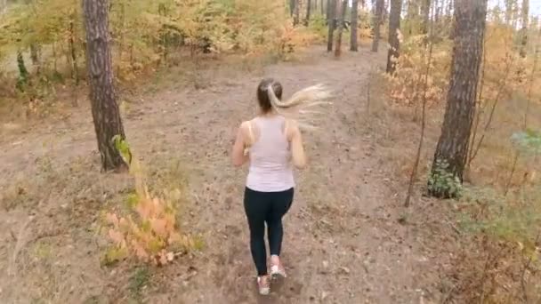 Lassított kilátás a csúcspontja az erdő jogging nő — Stock videók