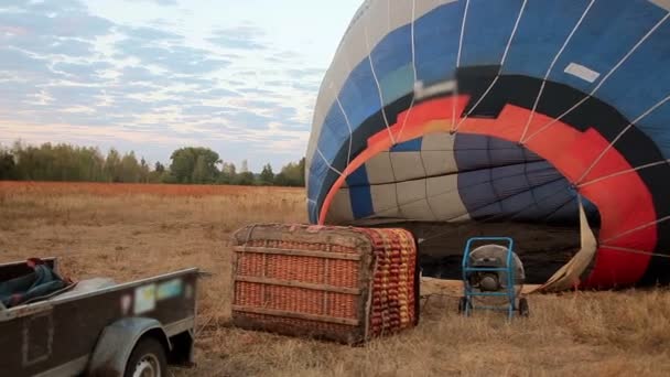 Большой воздушный шар перед полетом наполняется горячим воздухом на земле — стоковое видео