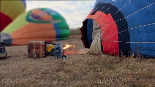Propane gas burner filling balloon with hot air on the field — Stock Video