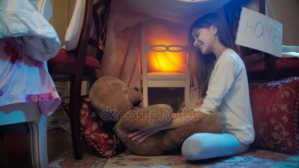 4k vídeo of cute girl playing with big teddy bear in self-made tent at night — Vídeo de Stock