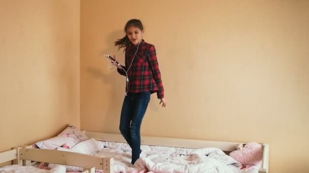 Повільне відео руху красивої дівчини-підлітка, яка танцює і співає в спальні — стокове відео