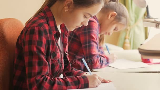 Närbild 4k film av tonårsflickor gör övning på klassrummet — Stockvideo