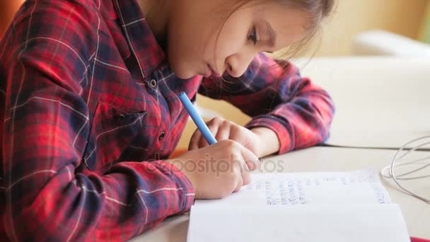 Closeup 4k vídeo de adolescente escrevendo exercício no copybook com caneta — Vídeo de Stock