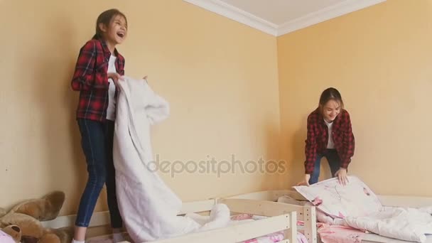 Duas meninas adolescentes alegres rindo e pulando em camas — Vídeo de Stock