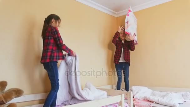 Slow motion séquences de deux filles gaies sautant sur le lit — Video