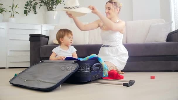 Dolly tiro de lindo niño ayudando a la madre a hacer las maletas para las vacaciones — Vídeos de Stock