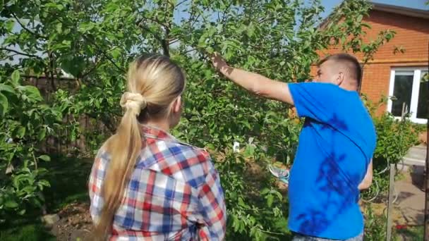 Zeitlupenaufnahmen eines älteren Mannes, der seine Tochter im Obstgarten unterrichtet — Stockvideo