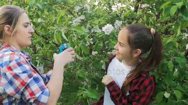 Teeange Kız annesinden nasıl Bahçe ve kuru erik ağaçlarının dikkat çekmek öğrenme — Stok video