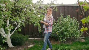 Mutlu kadın çiftçi Garden fidan içinde büyük tepsi ile yürüyüş ağır çekim görüntüleri