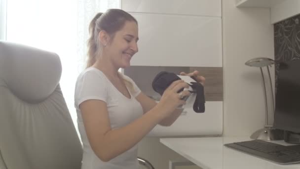 若い笑顔の女性は、バーチャルリアリティ ヘッド セットにしようとしています。4 k で撮影した映像 — ストック動画