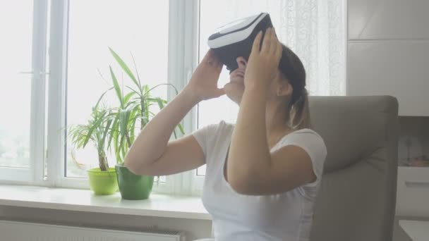 Mujer joven asombrada probándose el casco de realidad virtual. Filmación a 4K — Vídeos de Stock