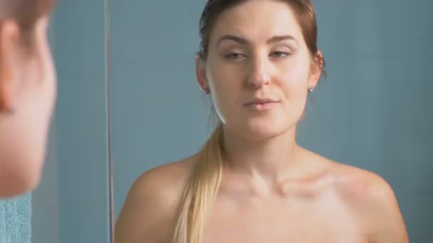 Portret van de jonge vrouw spiegel te kijken en controleren van haar gezicht — Stockvideo