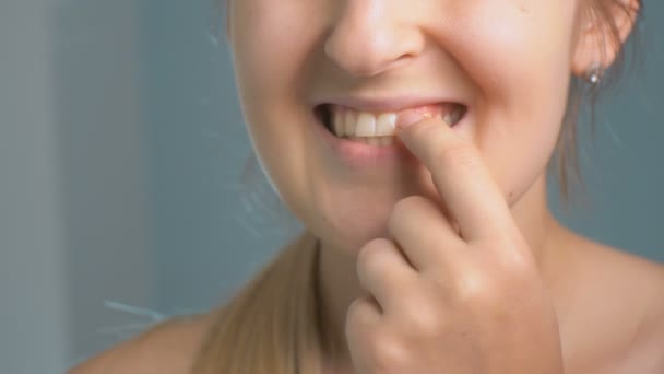 Close-up beelden van jonge vrouw alikruiken stuk van voedsel vast in tanden — Stockvideo