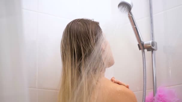 Slow motion video of beautiful brunette woman opens water at shower — Stockvideo