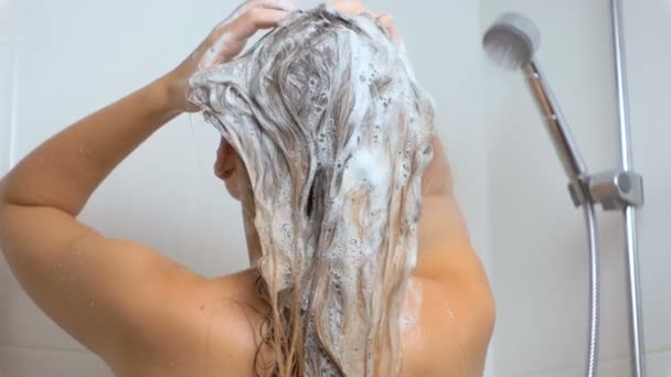 Zeitlupenaufnahmen von Frau mit langen Haaren, die Shampoo in der Badewanne aufträgt — Stockvideo