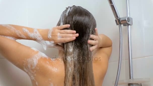 Sexy mujer morena lavando el cabello bajo la ducha — Vídeo de stock
