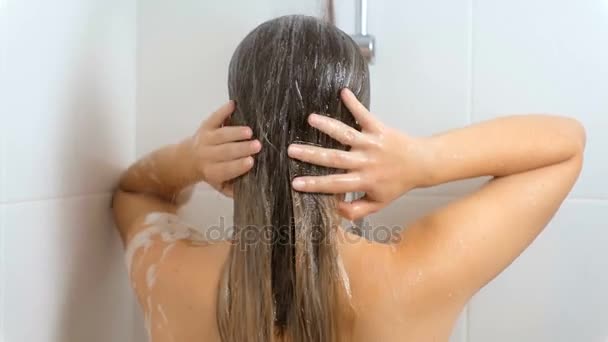 Rear view slow motion footage of sexy woman washing hair at shower — Stock Video