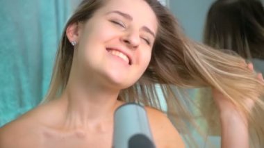 Ağır çekim video şarkı ve saç kurutma mutlu genç kadın