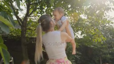 Mutlu neşeli kadın bebek oğlu ağacın altında orchard adlı kaldırma