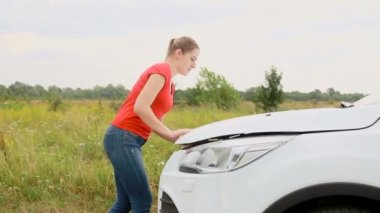 Genç kadın Başlık alanına kırık araba ve motora seyir açar üzgün